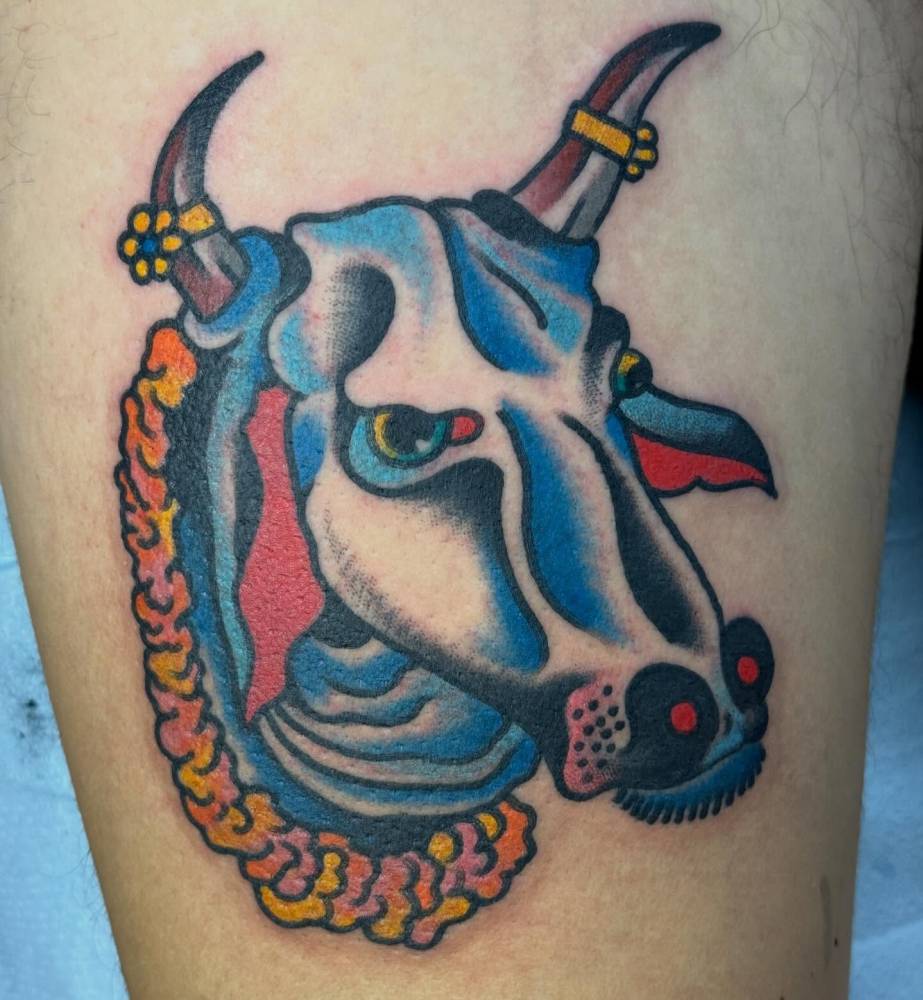 Bull portrait tattoo in traditional style located on the thigh.