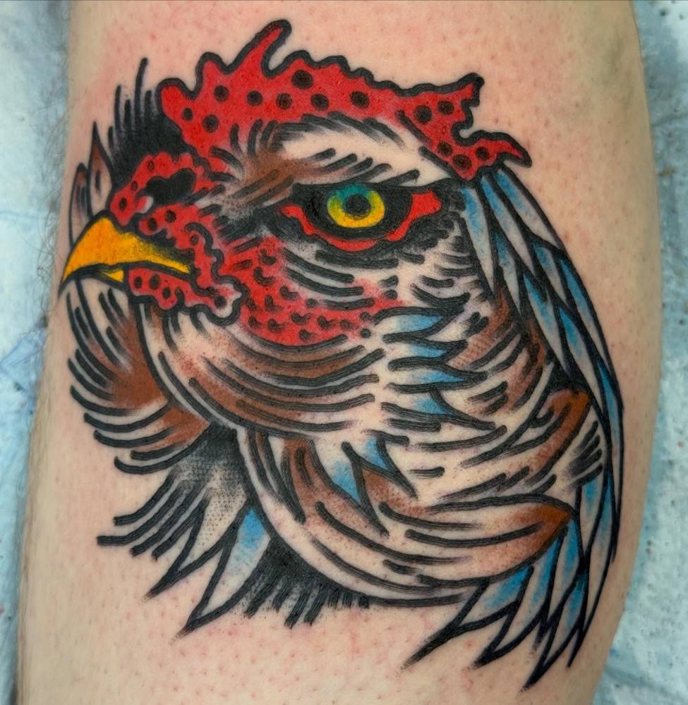 Chicken head in traditional style tattooed on the calf.