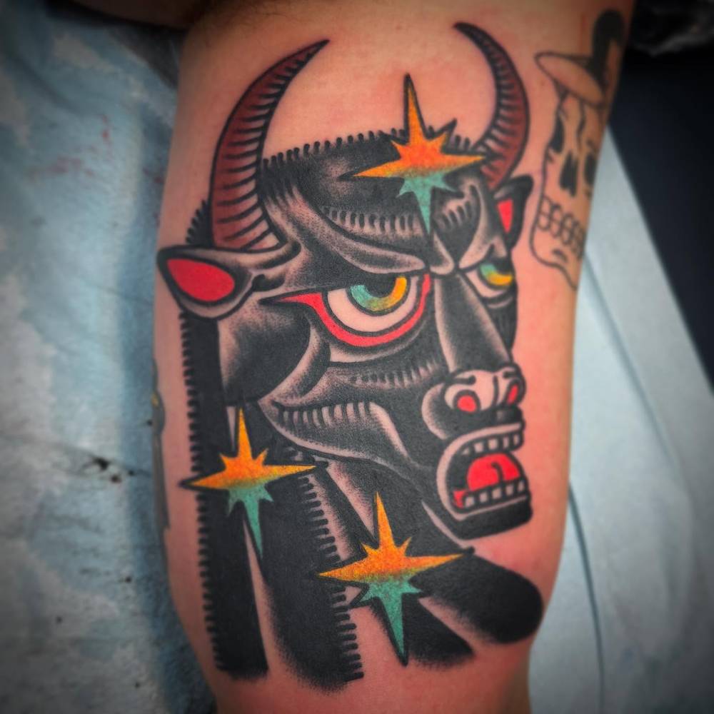 Bull portrait tattoo in traditional style done on the inner arm.