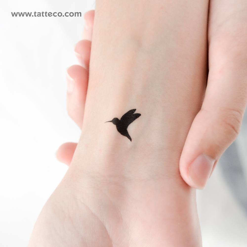 Tiny blackwork hummingbird temporary tattoo located on the wrist.