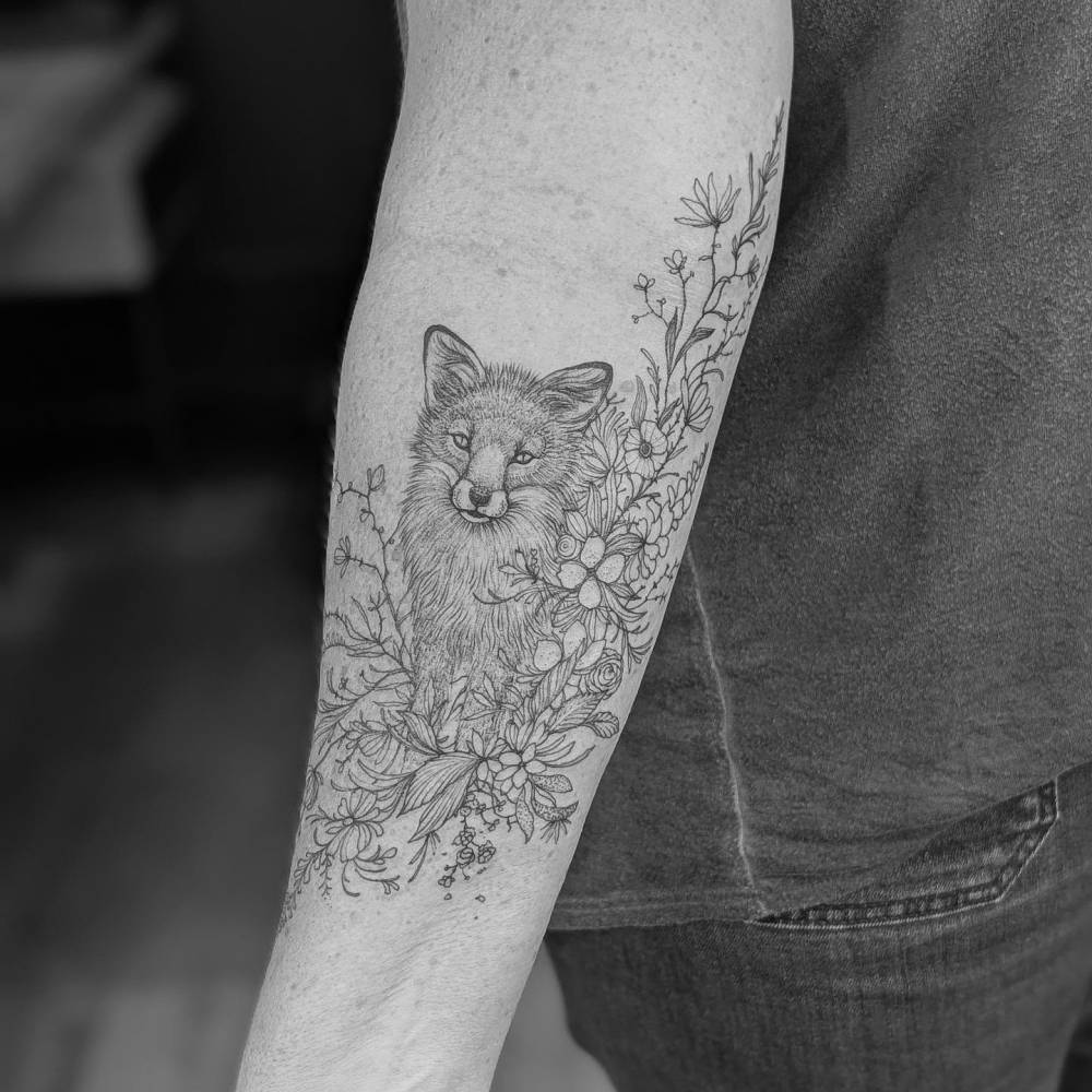 Lil' fox in illustrative style tattooed on the inner forearm.