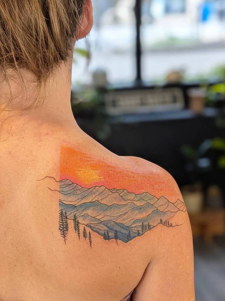 Mountain sunset tattoo located on the shoulder blade.