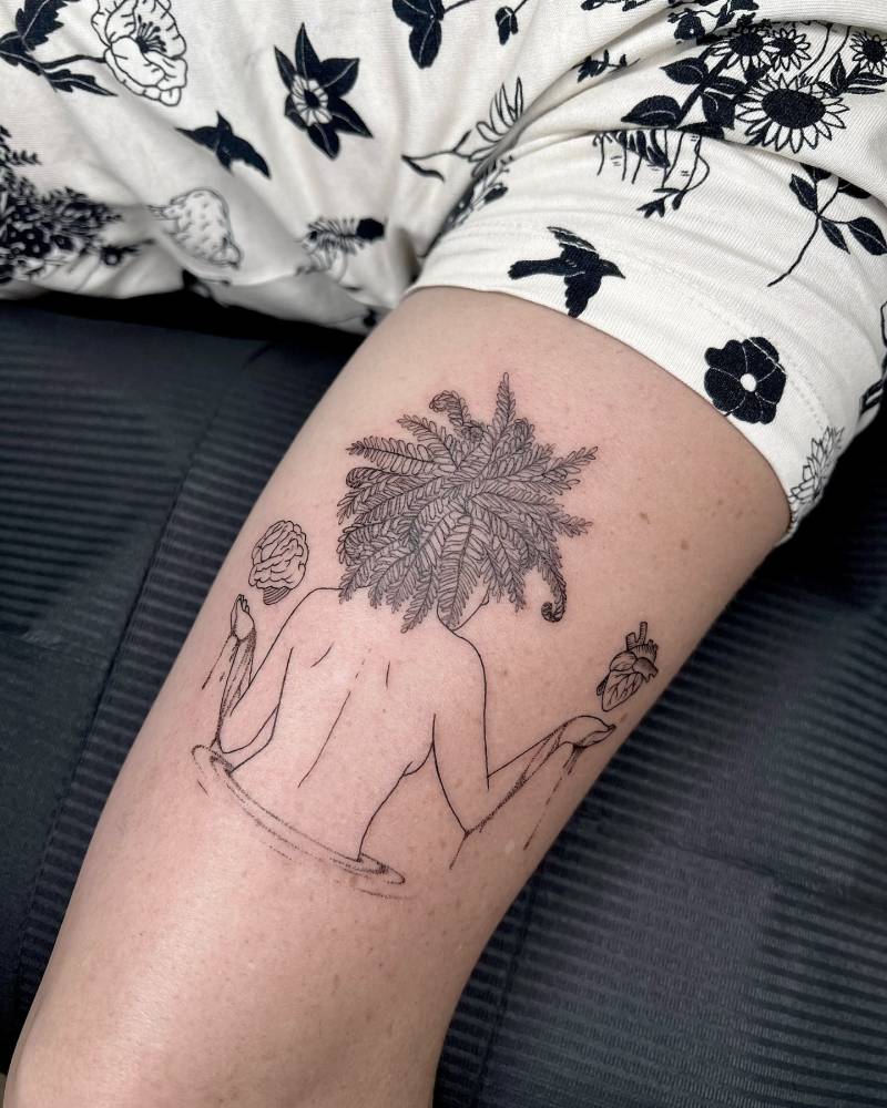 Flower head woman tattoo located on the tricep, illustrative style.