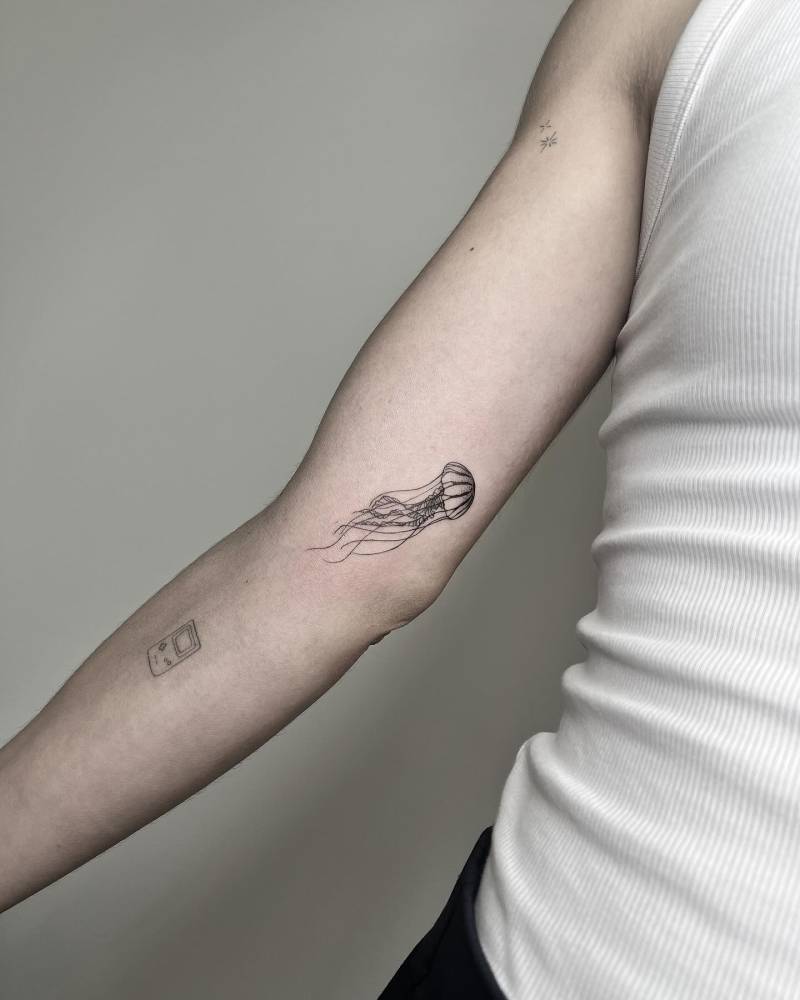 Little jellyfish tattoo located on the inner arm.