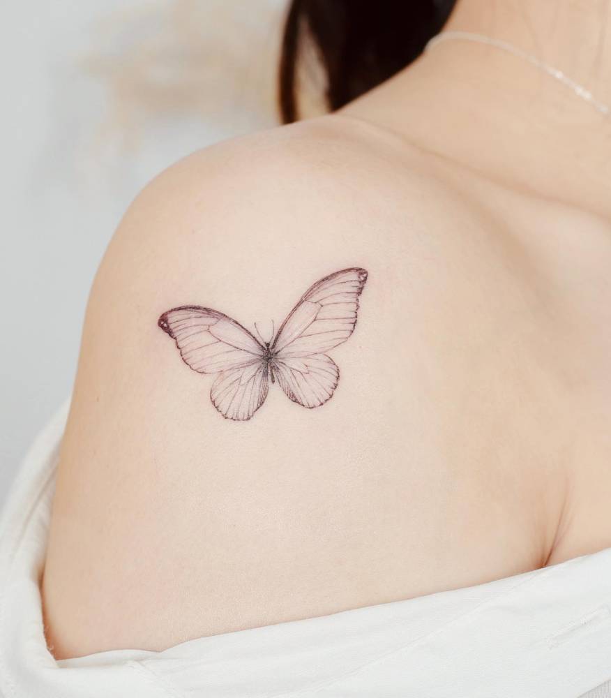 Butterfly tattoo in watercolor style located on the shoulder.