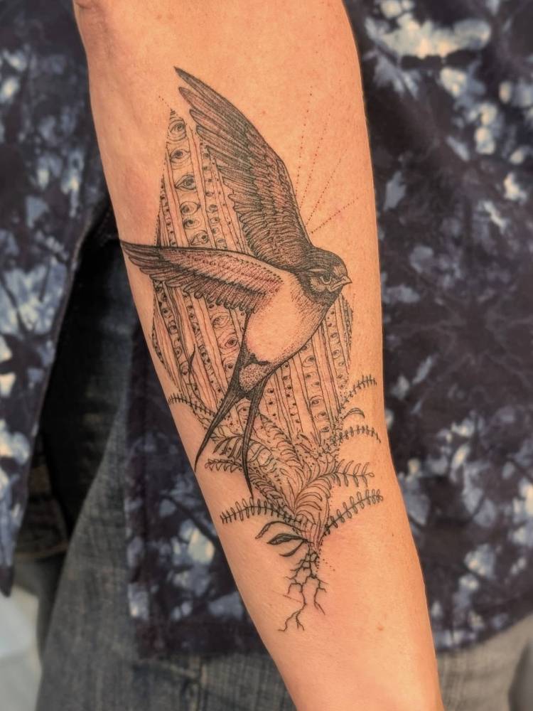Swallow tattoo in illustrative style done on the forearm.