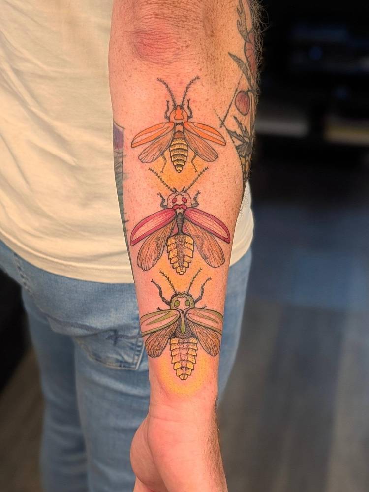 Fireflies trio tattooed on the forearm, illustrative style.