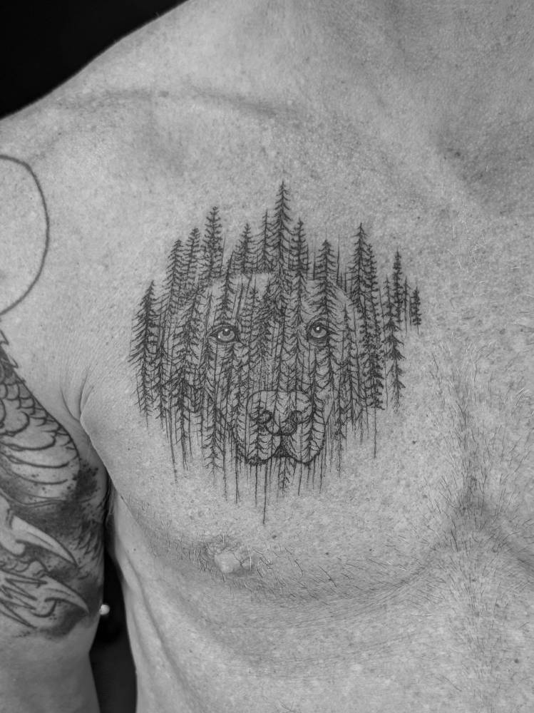 Labrador portrait and forest tattoo located on the chest.
