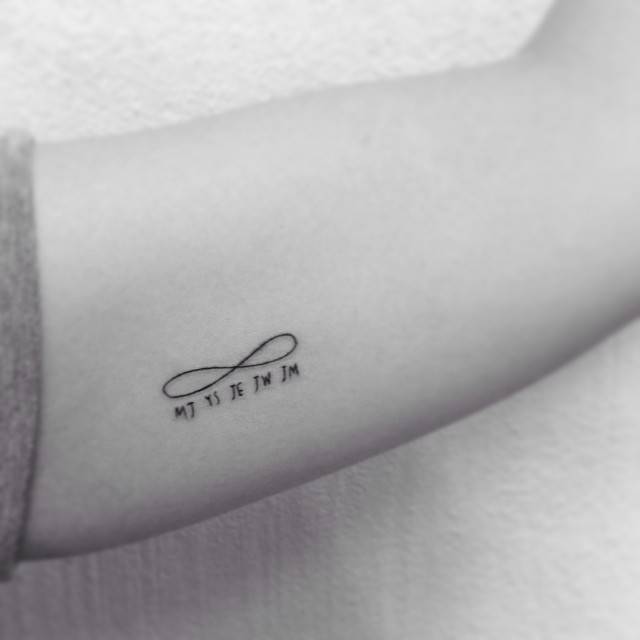 Infinity symbols and initials tattoo located on the inner arm.