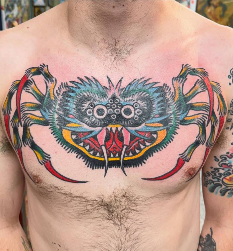 Spider tattoo in traditional style located on the chest.