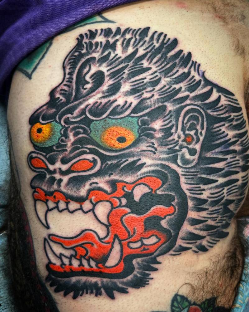 Butt cheek gorilla portrait tattoo in traditional style.