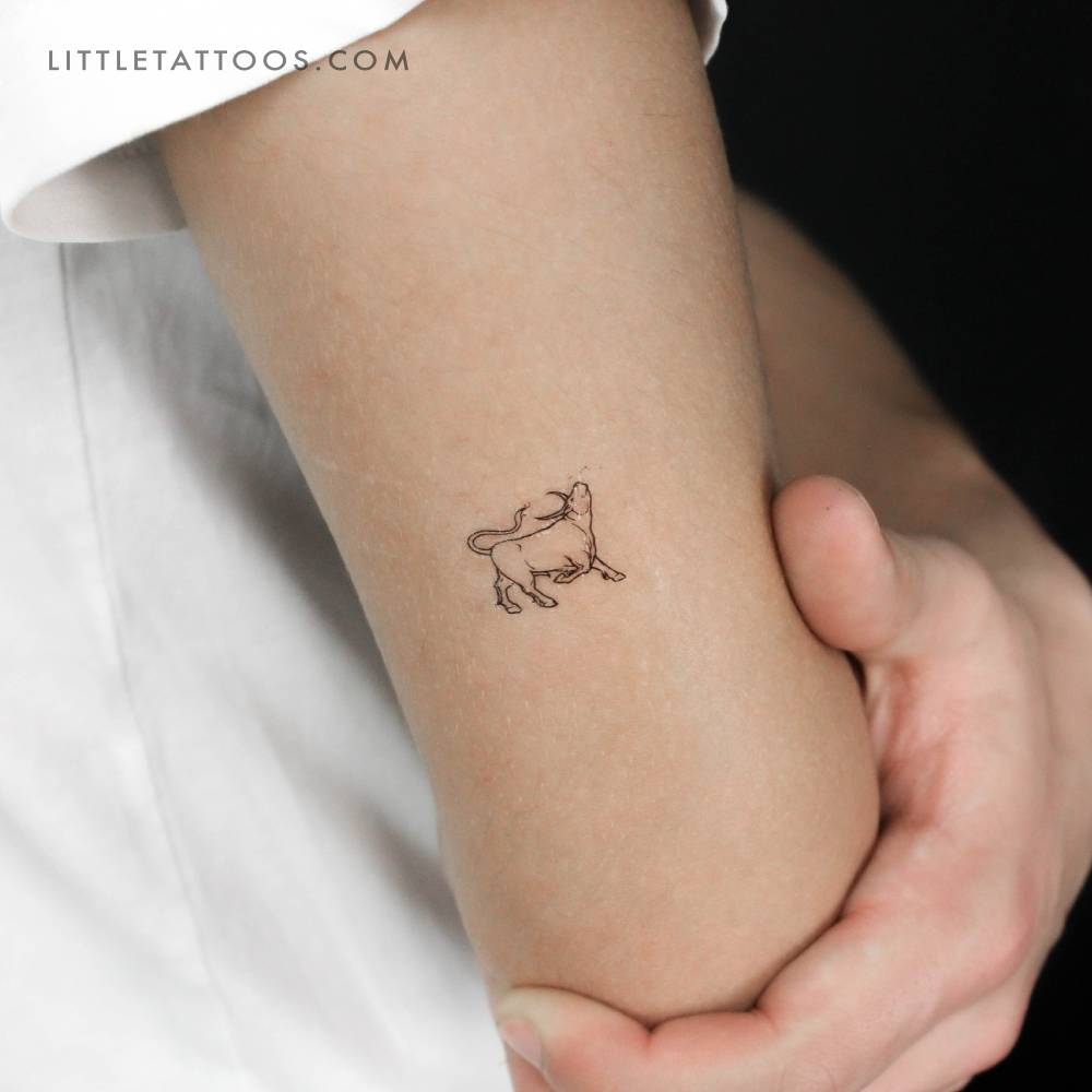 Fine line style bull temporary tattoo located on the tricep.