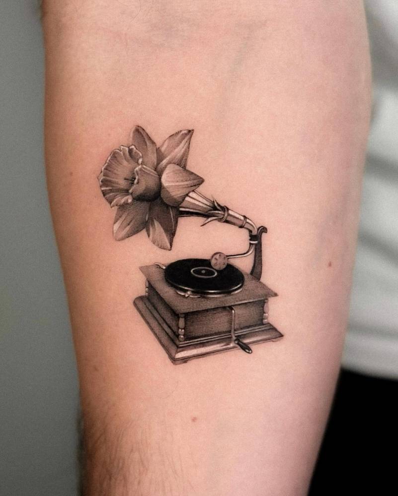 Daffodil gramophone tattoo located on the inner forearm.