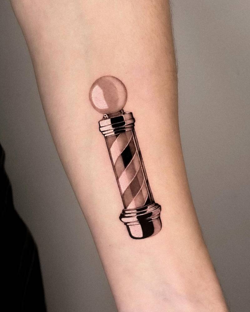 Barber pole in micro-realism tattooed on the inner forearm.