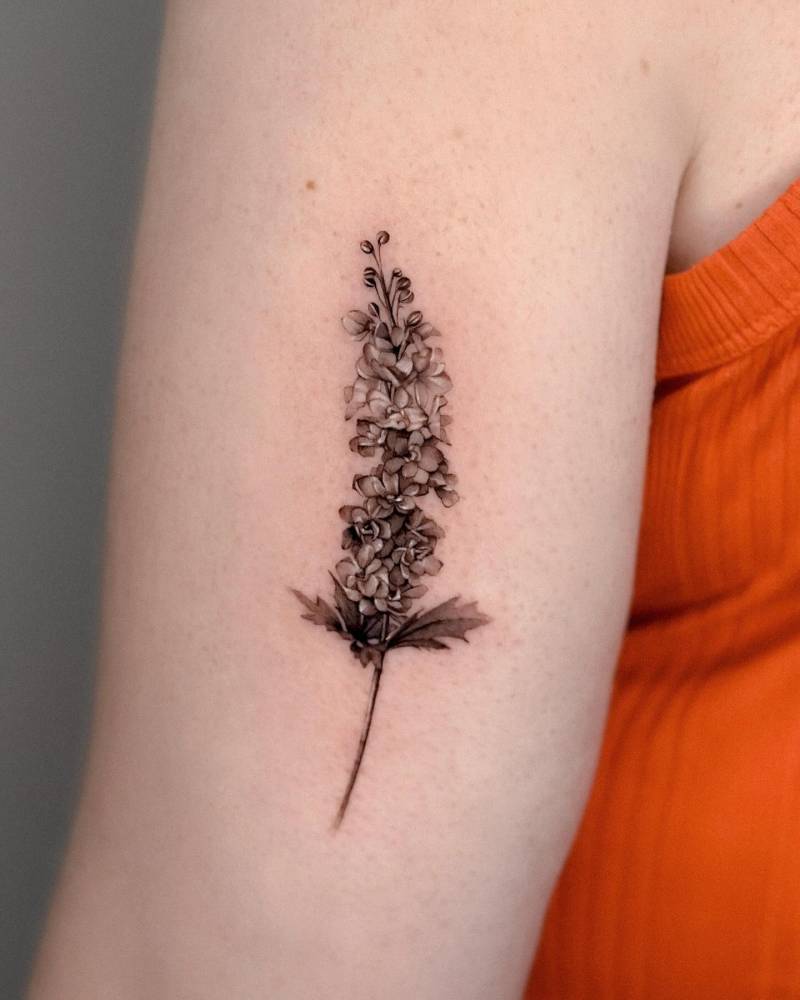 Larkspur tattoo in micro-realism located on the tricep.