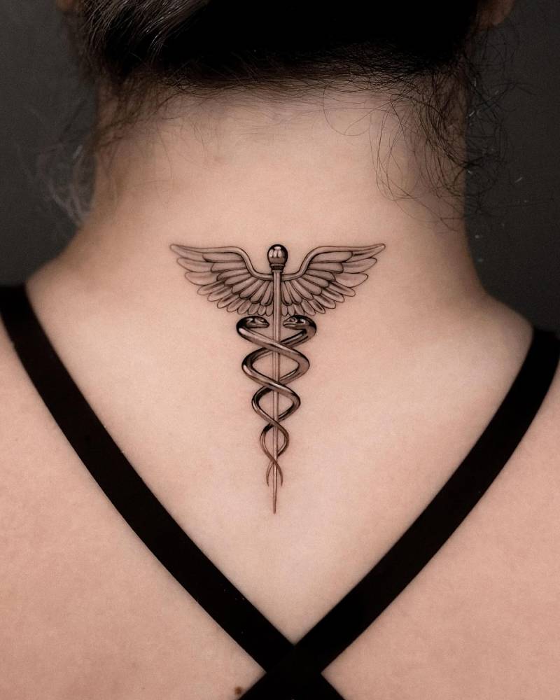 Caduceus tattoo located on the upper back in micro-realism.