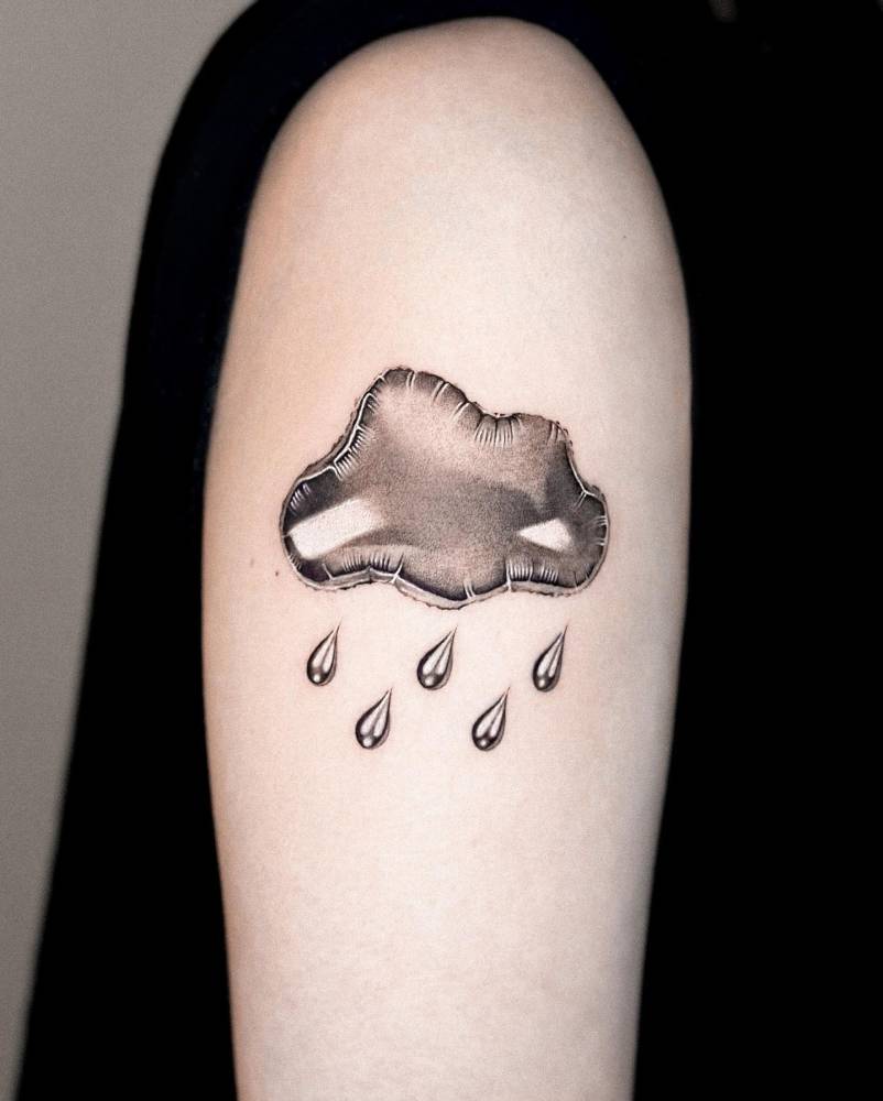 Balloon cloud and rain tattoo located on the upper arm.