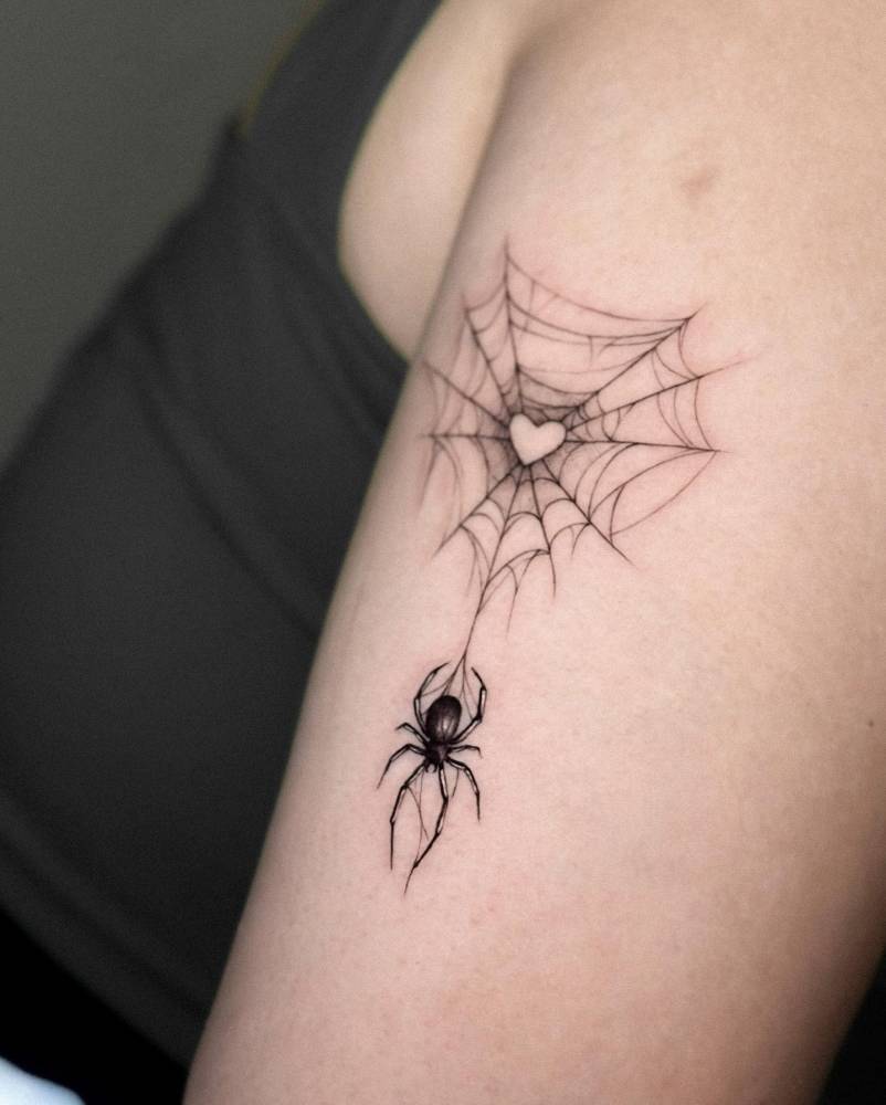Spider and web tattoo located on the upper arm.