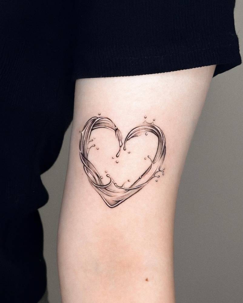 Wave heart tattoo in micro-realistic style located on the bicep.