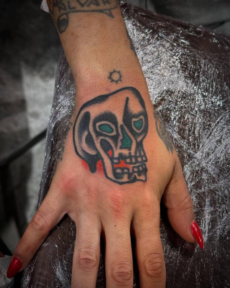 Traditional style skull tattoo located on the hand.