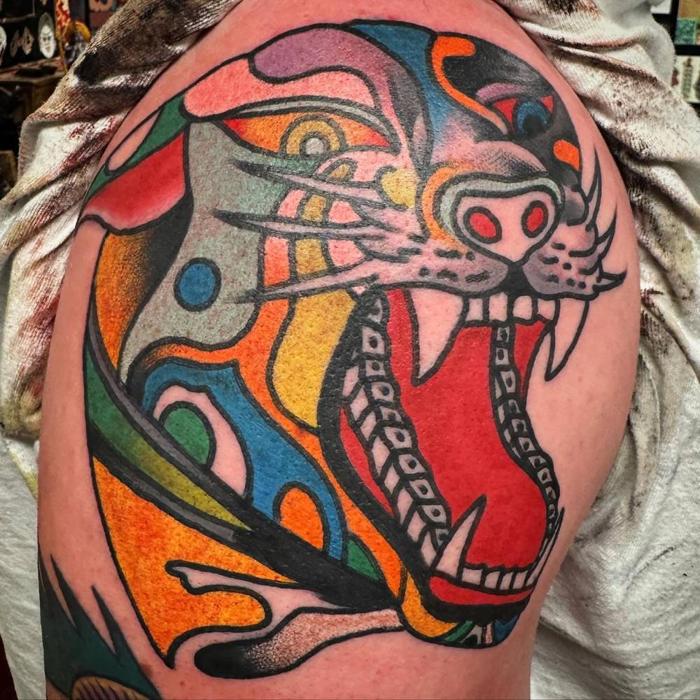 Panther head tattoo in traditional style located on the upper arm.