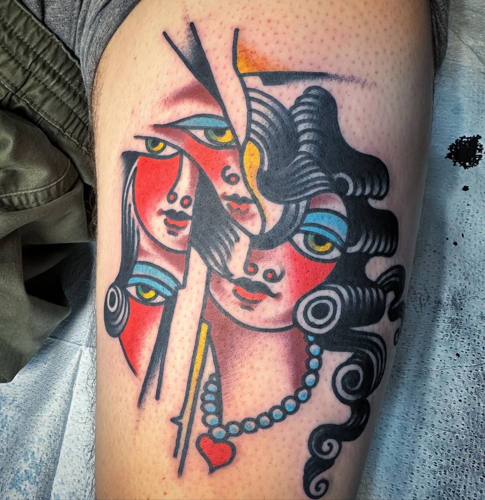 Abstract woman portrait tattoo located on the thigh.