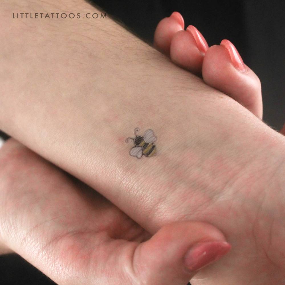Silver bee temporary tattoo located on the wrist.