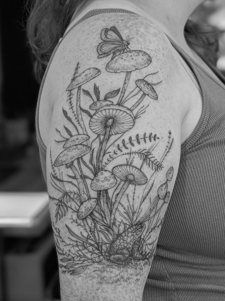 Mushrooms tattoo located on the upper arm, done in illustrative style.