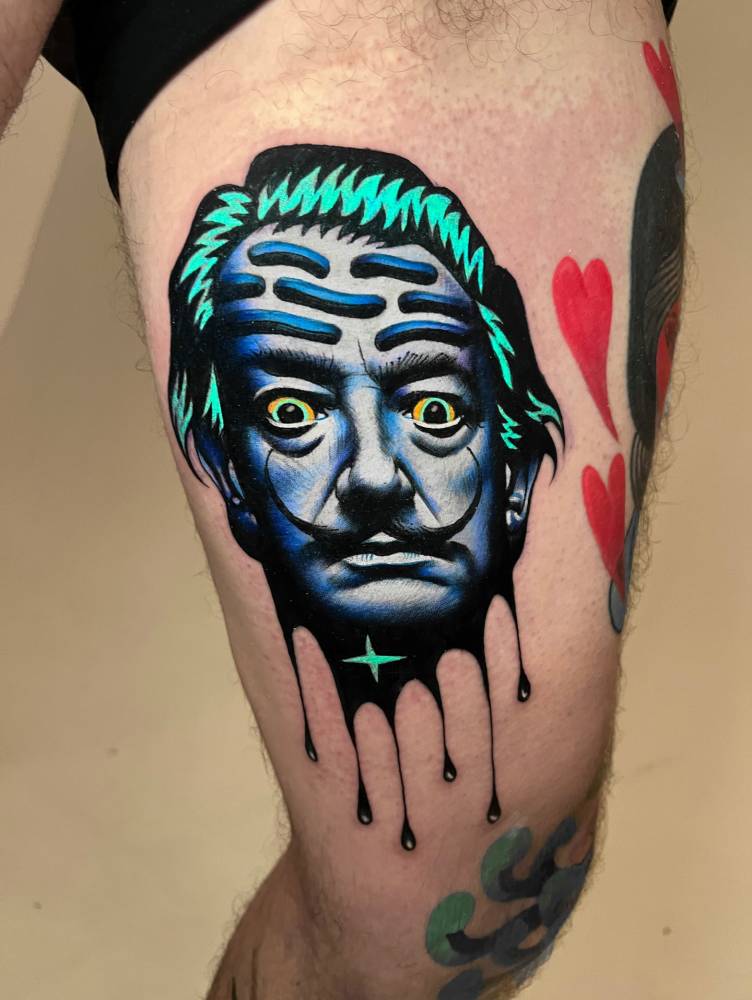 Surrealistic Dali portrait tattoo located on the inner arm.
