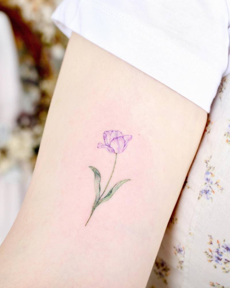 Watercolor style tulip tattoo located on the inner arm.