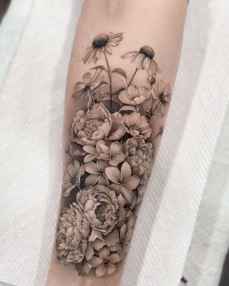 Floral collection tattoo located on the inner forearm.