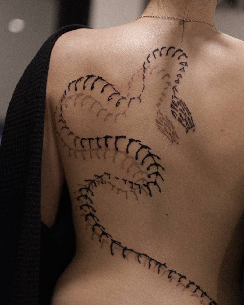 Snake skeleton tattoo in blackwork style done on the back.