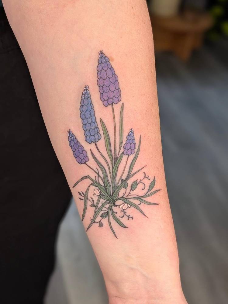 Grape hyacinth tattoo located on the inner forearm, illustrative style.