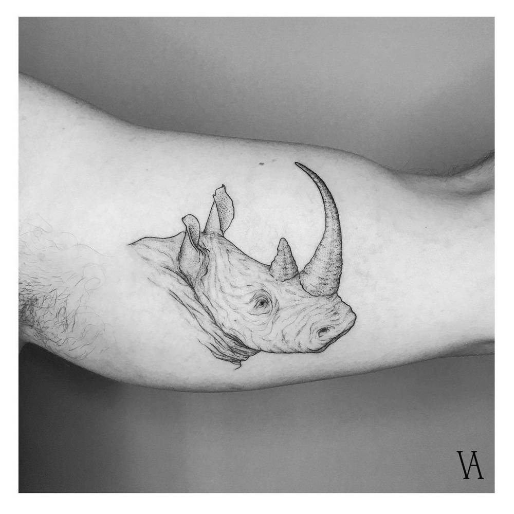 Rhino portrait tattoo located on the inner arm, illustrative style.
