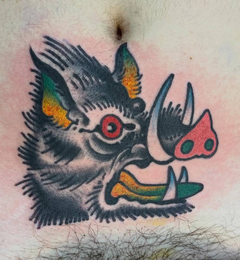 Wild pig portrait tattoo in traditional style done on the stomach.