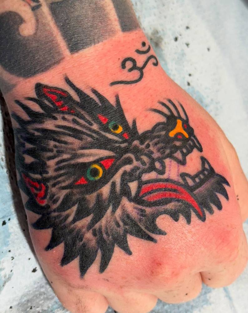Traditional style wolf head tattoo located on the hand.