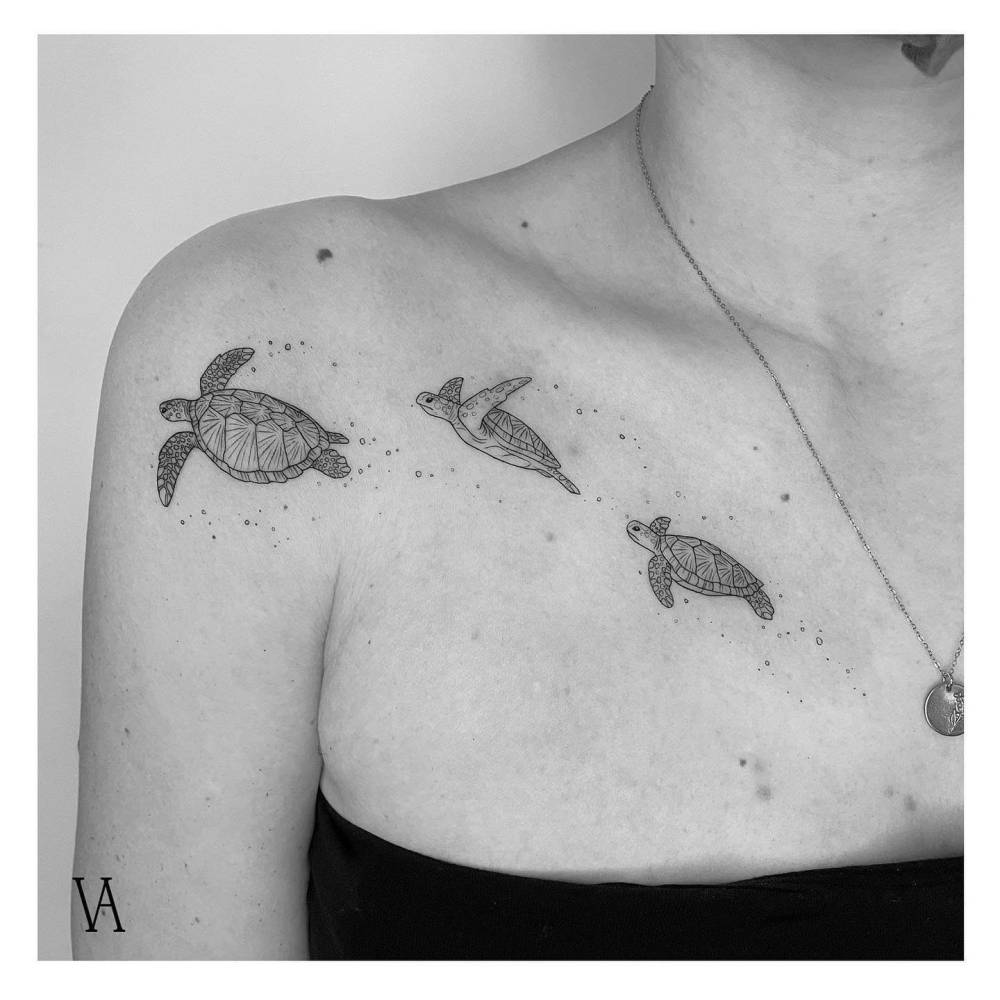 Three little turtles tattooed on the collarbone and shoulder.