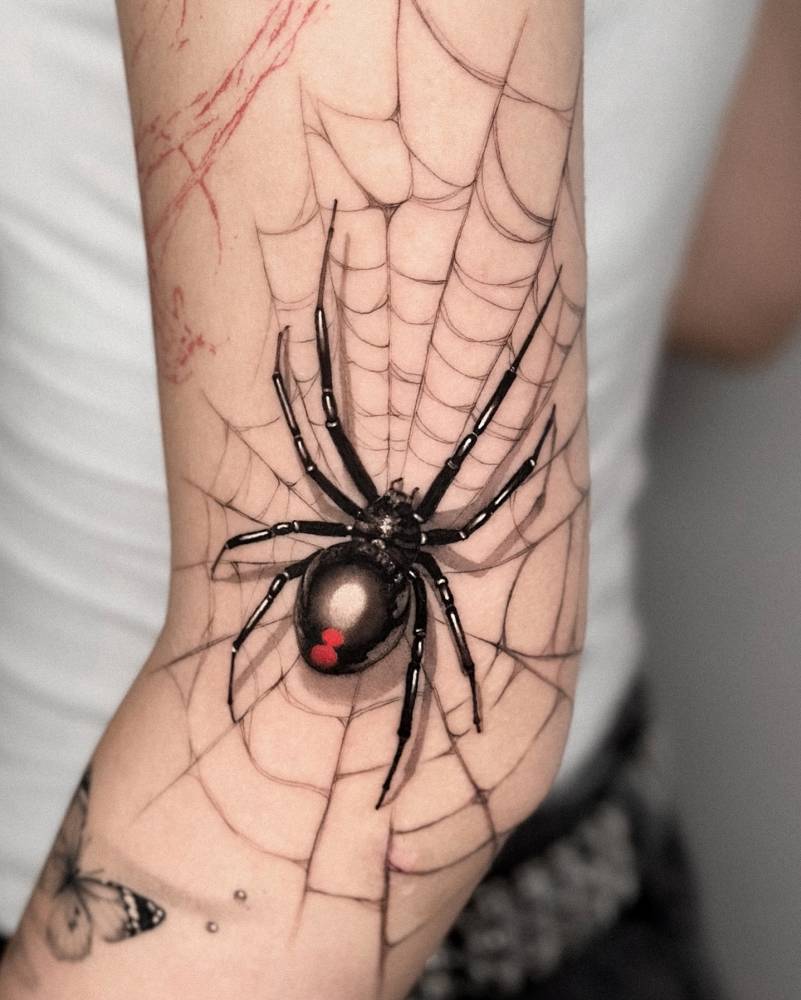 Spider and web tattoo located on the elbow.