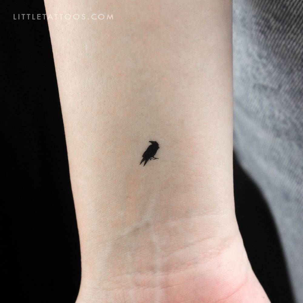 Tiny crow temporary tattoo located on the wrist.