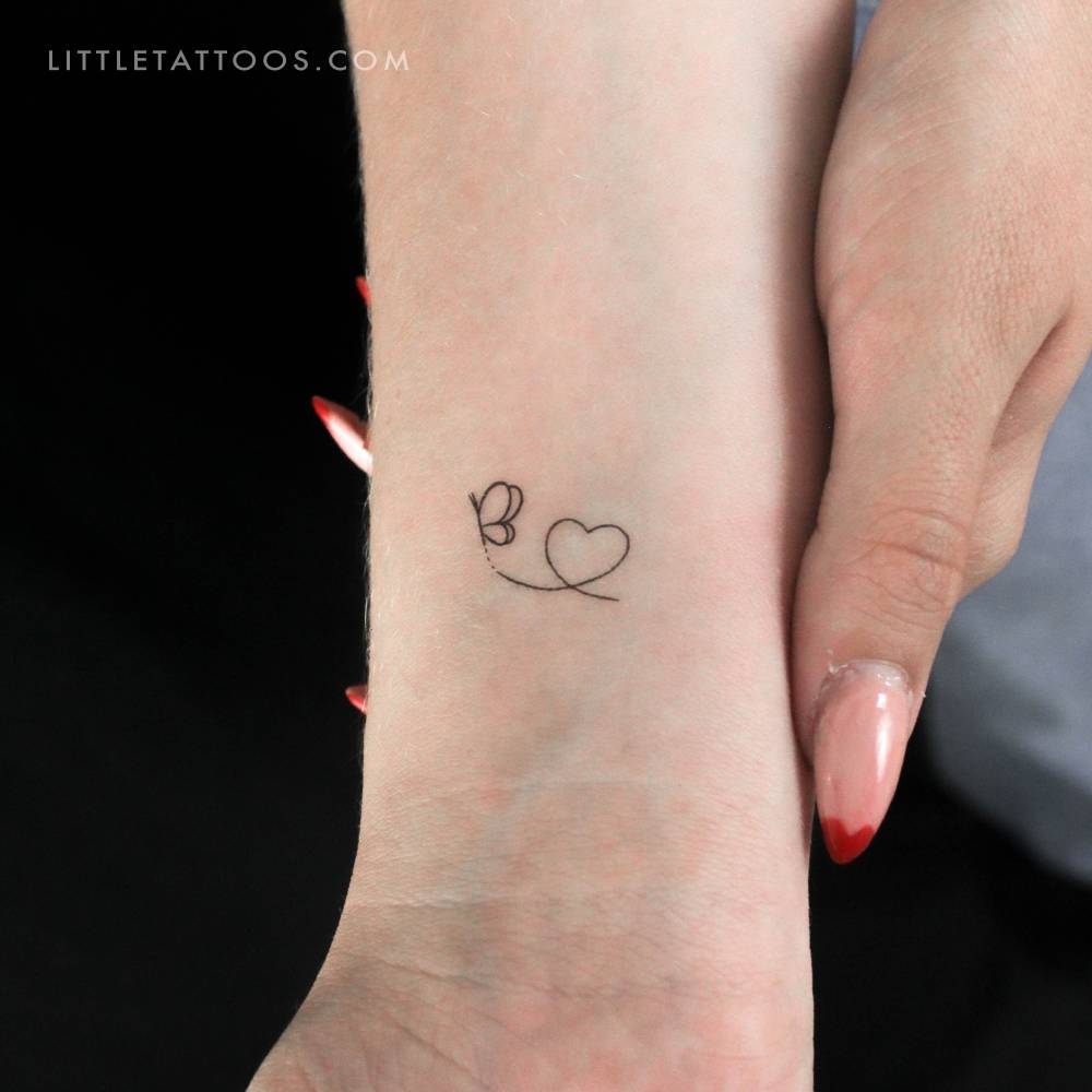 Butterfly heart temporary tattoo placed on the wrist.