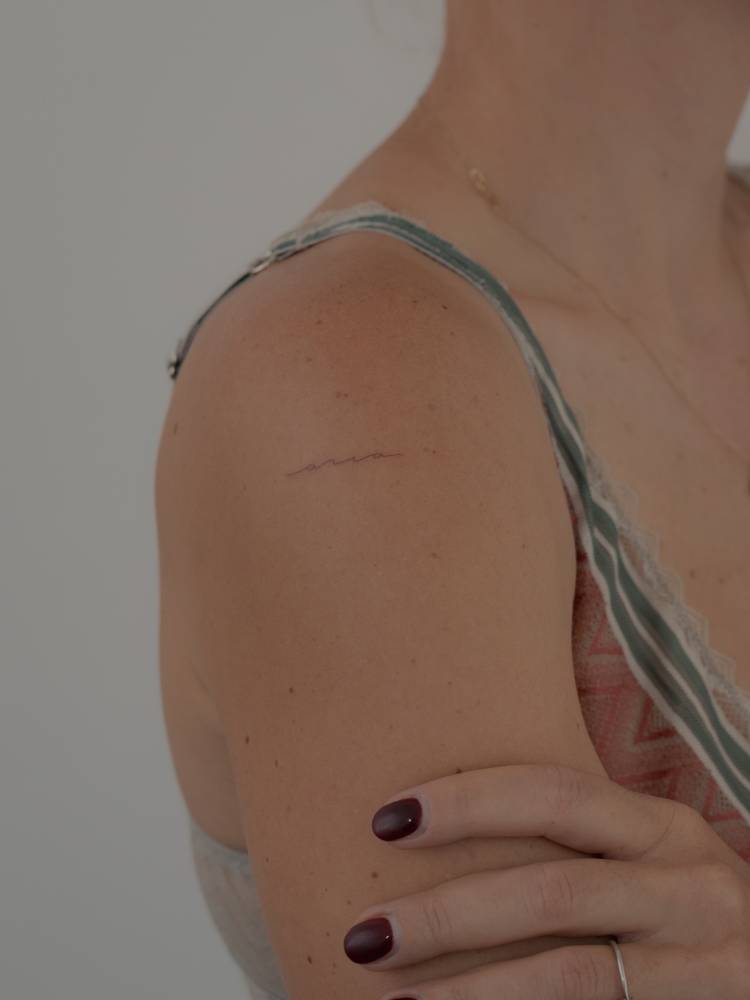 Handwritten font name "Aria" tattooed on the upper arm.