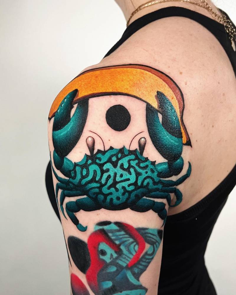 Crab holding a banana tattooed on the shoulder.