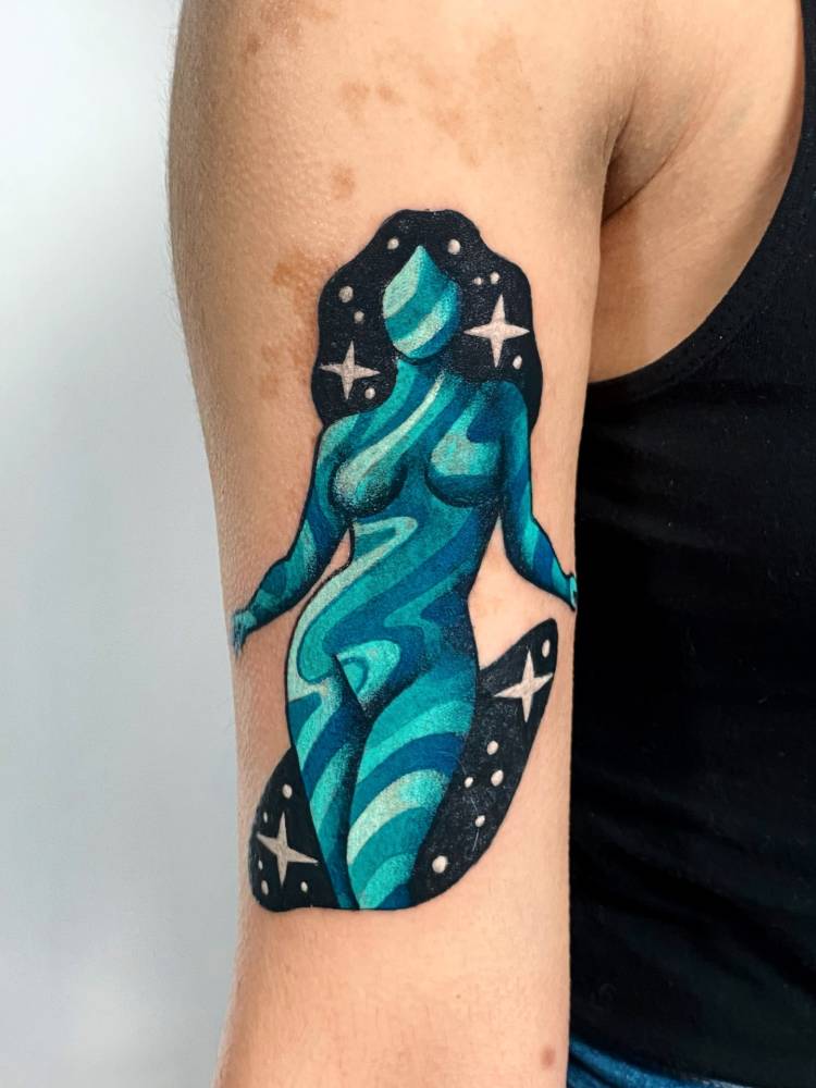 Nude woman tattoo located on the bicep.