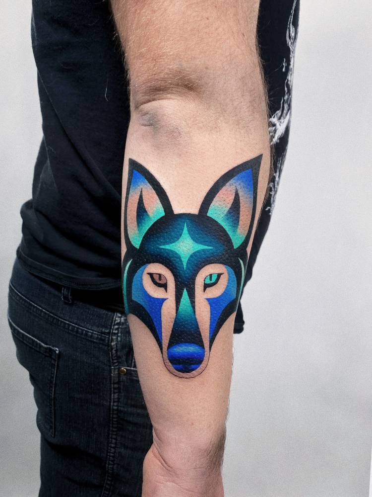 Wolf head tattoo in pop art style done on the forearm.