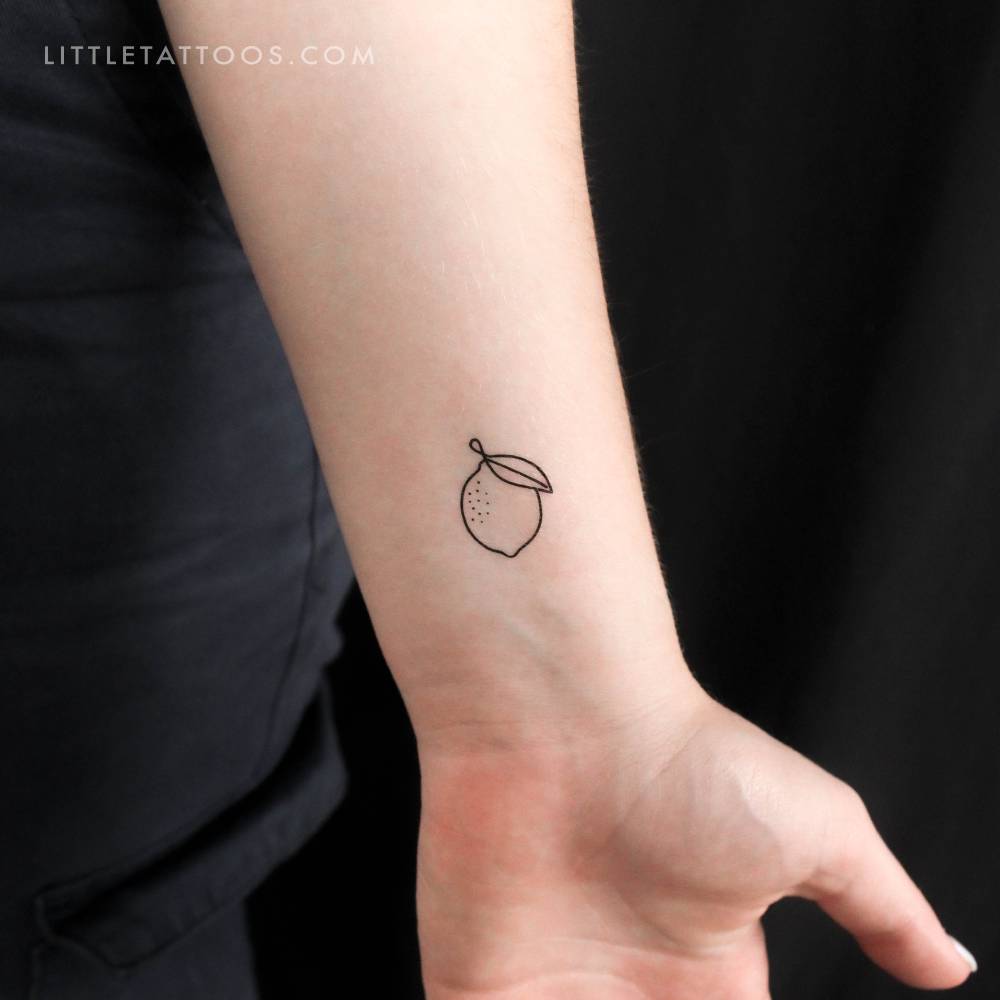 Minimalist lemon temporary tattoo located on the wrist.