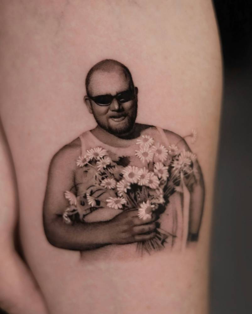 Her father’s portrait tattooed on the inner forearm, done in micro-realism.