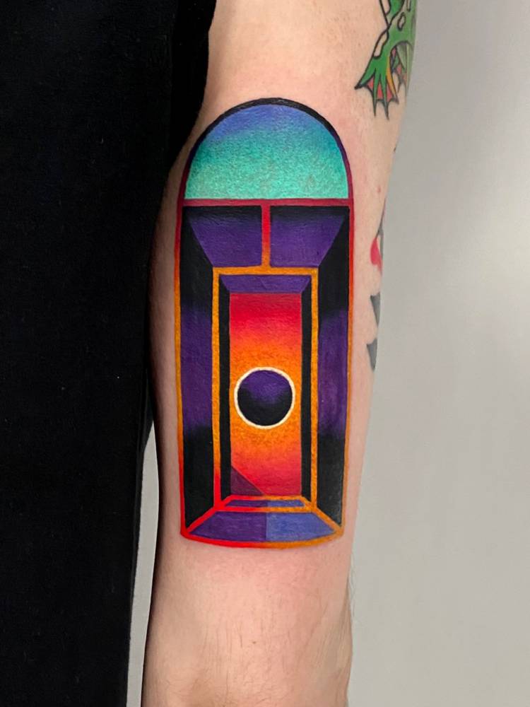 Pop art style door tattoo located on the tricep.