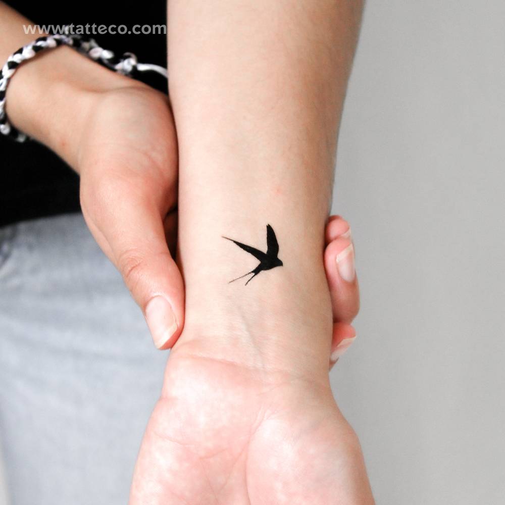 Black swallow temporary tattoo located on the wrist.