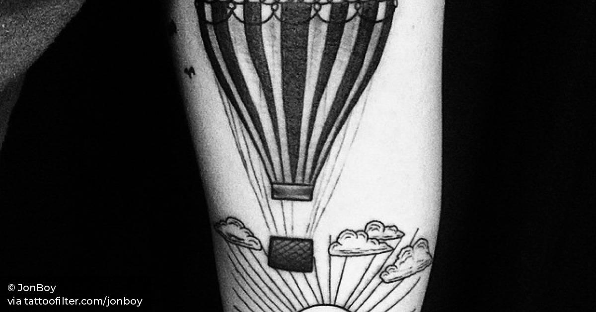 Air ballon and sunset tattoo on the left inner arm.