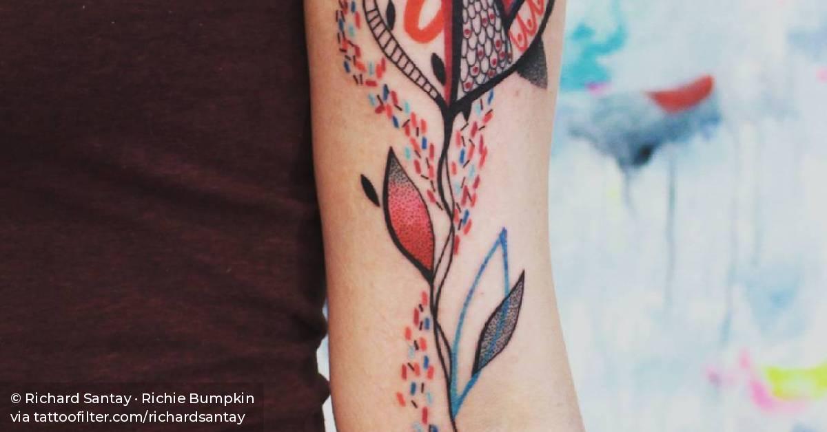 Abstract heart flower tattoo on the left inner arm.
